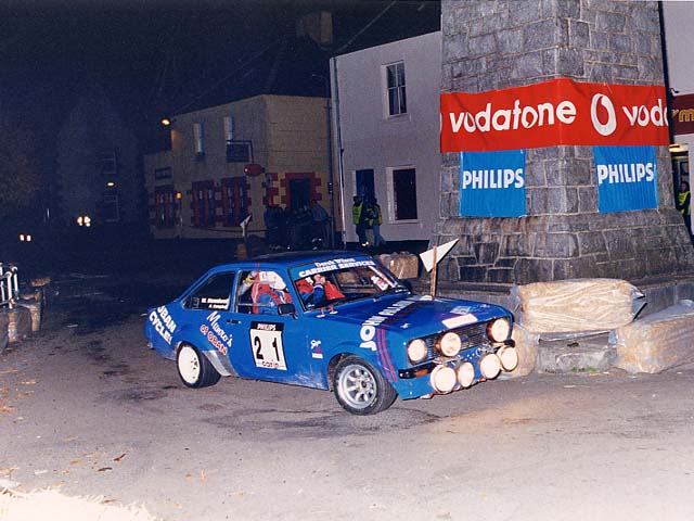 Sixth overall, First in Class C and "Best Scottish Crew" award - Willie Bonniwell and Ali Campbell in their Ford Escort Mk2 1998 going round the Clock Tower in Tobermory High Street on Friday Night's Millennium Stage